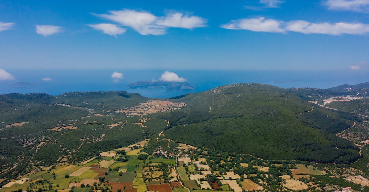 Aerial View of Mountains with Crops in the Valley and Sea in the Background 