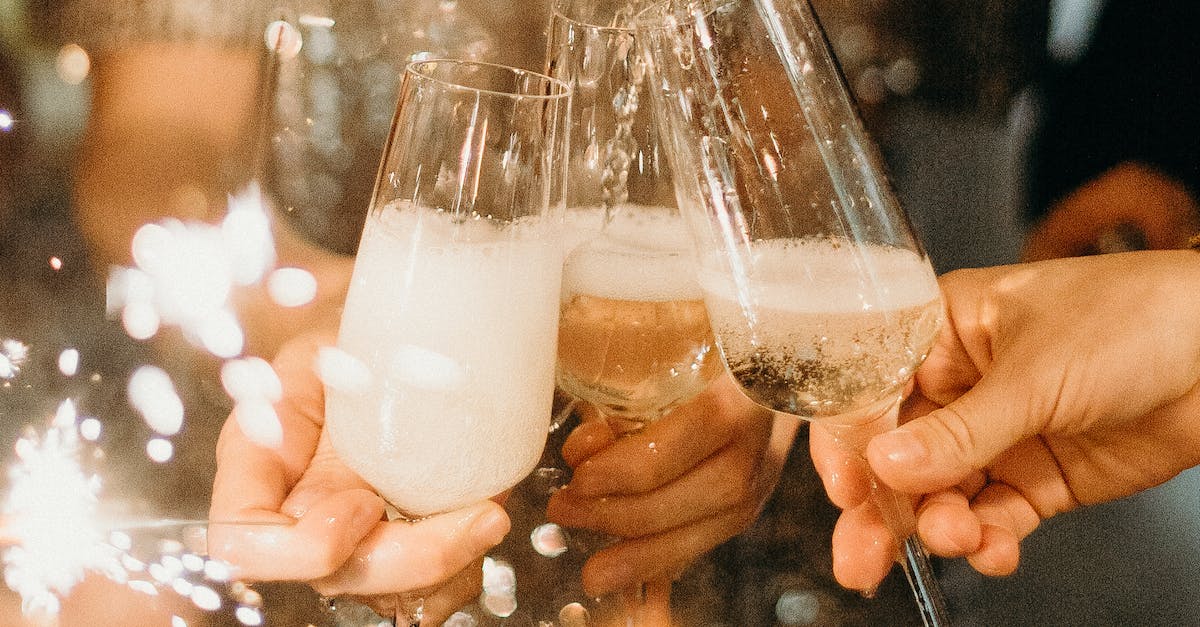Person Pouring Champagne on Champagne Flutes