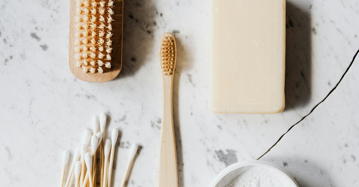 Top view composition of wooden cleaning brush and soap and toothbrush and tooth powder and cotton swab placed on marble surface with line chip