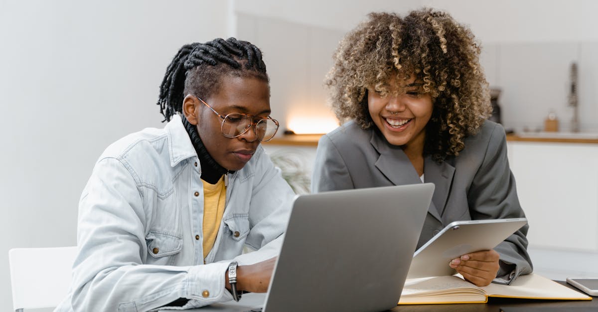 A Man and Woman Having Conversation while Sitting Near the Table with Laptop