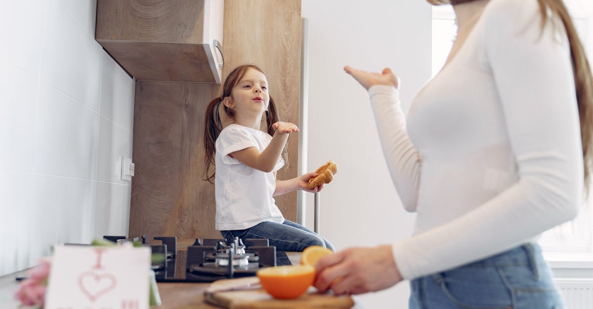 Loving mother and daughter blowing kiss on kitchen