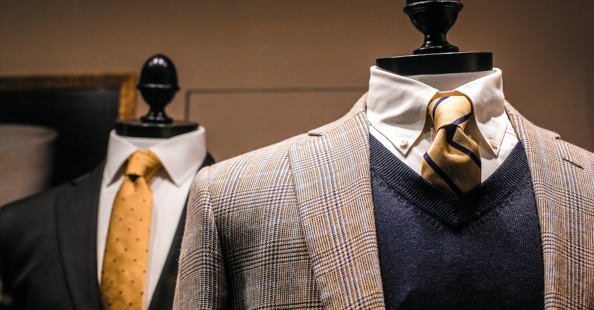 Dandy fancy jackets with shiny ties on dummies in showroom of contemporary male shop