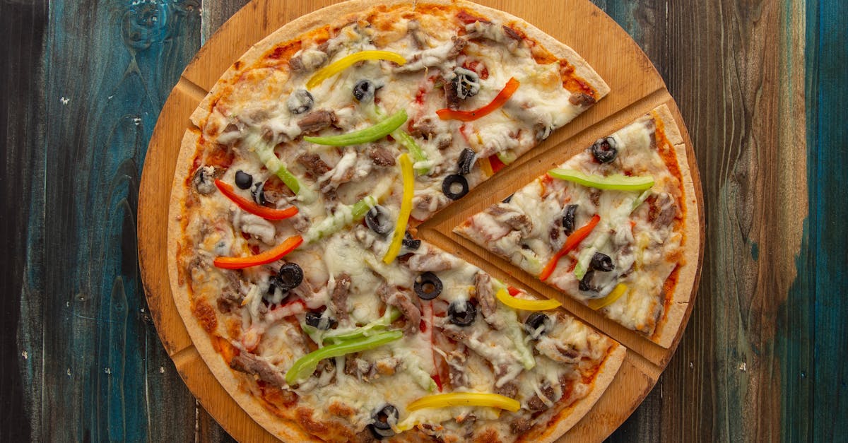 A pizza with pepperoni, mushrooms and olives on a wooden cutting board