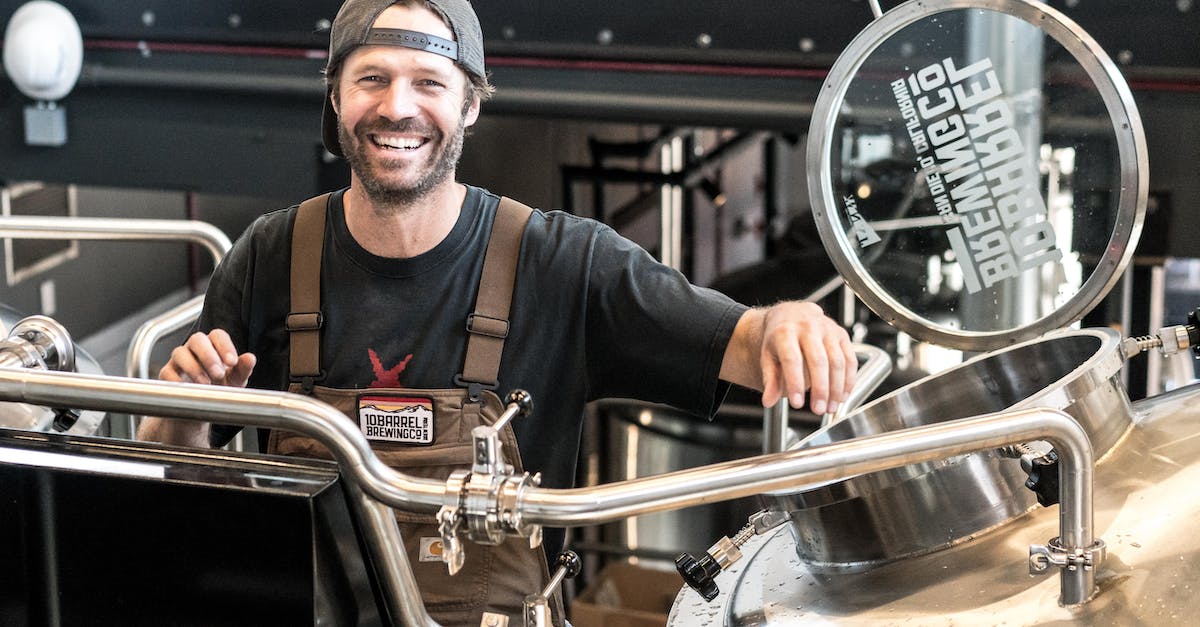 Happily Smiling Man Standing Near Gray Bars