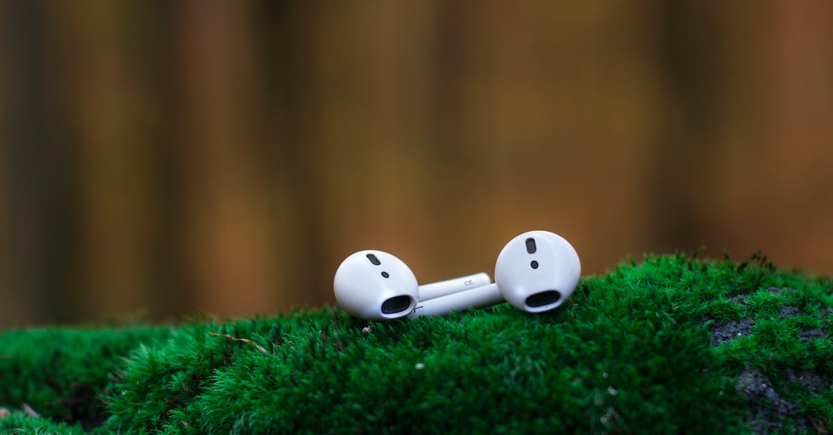Shallow Focus Photography of White Airpods on Green Surface